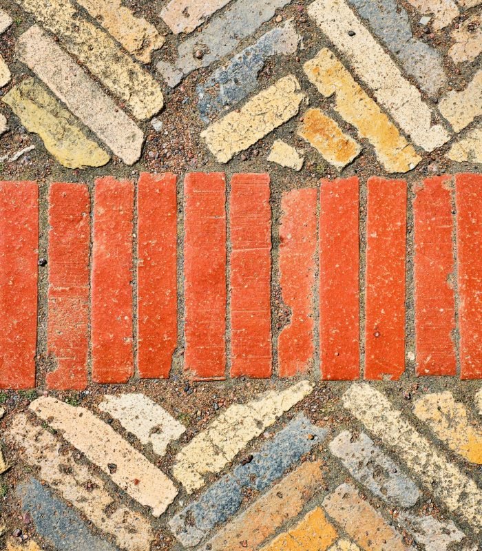 Abstract background from old brick ceramic cobblestone, top view. Old paths laid out in geometric patterns on granite chips. The idea of wallpaper for a table or a screensaver for advertising